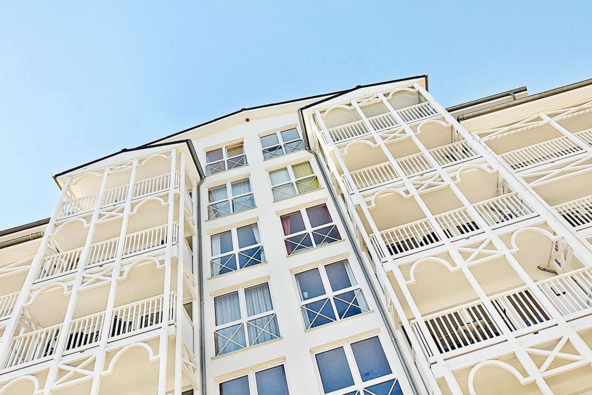 A multi-story building with balconies and large windows.