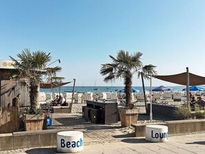 Ett avslappningsområde vid stranden med sittplatser och utsikt över havet.