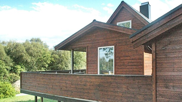 A wooden house with a balcony, a chimney, and a window. - Holiday Home in Vevang (Hustadvika)