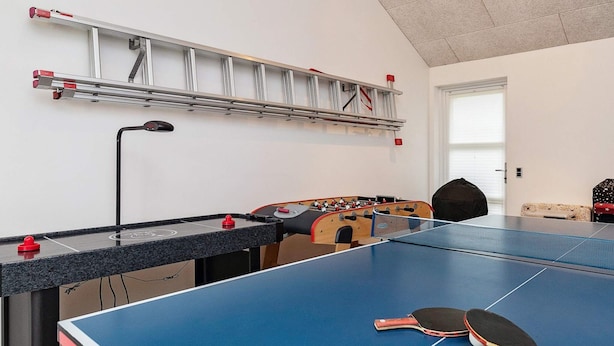 A room with a ping pong table, a foosball table, and a ladder against the wall. - 5 Star Holiday Home in Brovst (Brovst)