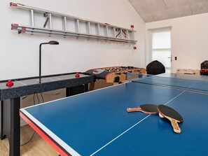 Et rum med et ping-pong bord, et bordfodboldbord og en stige op ad væggen.