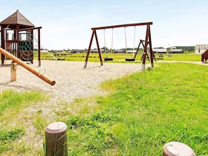 A playground with swings and a climbing structure.