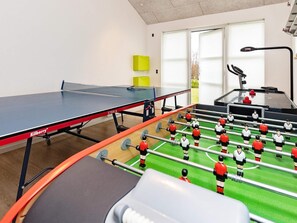 A room with a ping pong table, a foosball table, and a treadmill.