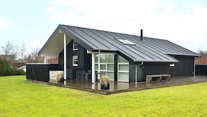 A modern house with a large glass door entrance, a covered patio, and a metal roof. - 5 Star Holiday Home in Brovst (Brovst)