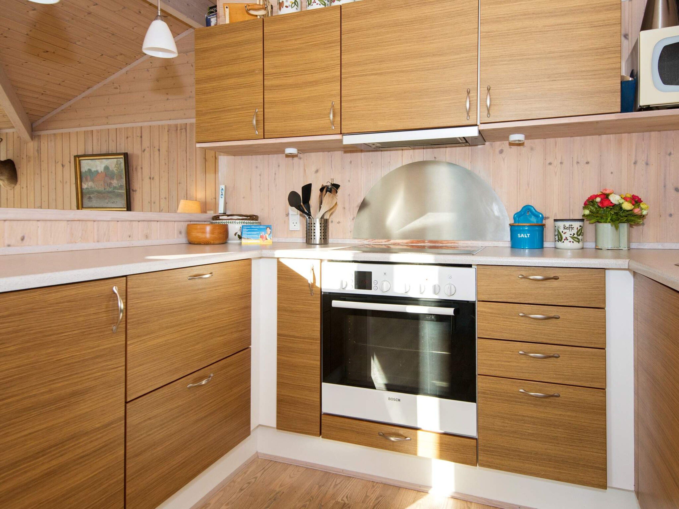 A kitchen with wooden cabinets, a Bosch oven, and a microwave.