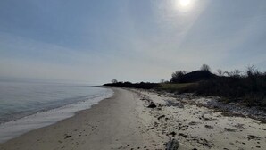 Uma praia com céu limpo e o sol brilhando.