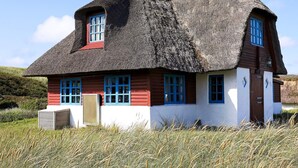 A traditional thatched-roof house with multiple windows and a chimney. - 5 Person Holiday Home in Ulfborg (Ulfborg)