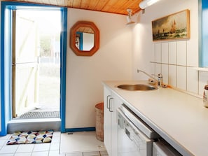 Cozinha compacta com pia, lava-louças e janela com vista para o exterior.