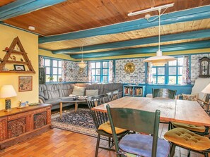 Un área de comedor acogedora con una mesa de madera, sillas y un sofá.
