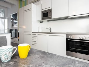 A modern kitchen with white cabinetry, a microwave, a coffee maker, and a Siemens oven. - Holiday Home in Wendtorf (Wendtorf)