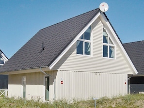 A single-story building with a gabled roof, a satellite dish, and a small door. - Holiday Home in Wendtorf (Wendtorf)