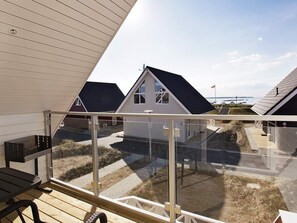 A modern building with a sloped roof, large windows, and a view of the beach. - Holiday Home in Wendtorf (Wendtorf)