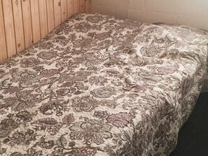 A bed with a floral patterned bedspread in a room with wooden walls. - 6 Person Holiday Home in Vinderup (Vinderup)