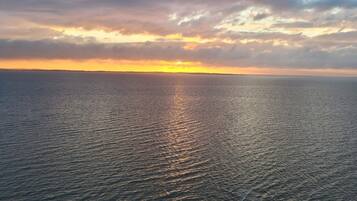 A calm sea at sunset with a clear horizon.