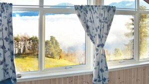 A room with a large window overlooking a forested area and mountains. - 6 Person Holiday Home in Blaksæter (Stryn)