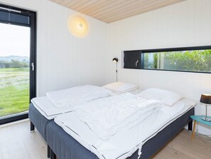 A bedroom with a bed, a window, a bedside table, and a lamp. - Simplistic Holiday Home in LÃ¸gstrup near Sea (Logstrup)