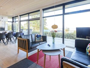 A modern living space with a sofa, chairs, a round table, and a TV. - Simplistic Holiday Home in LÃ¸gstrup near Sea (Logstrup)