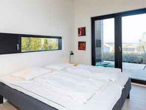 Un dormitorio moderno con una cama grande, una ventana y vistas al exterior.