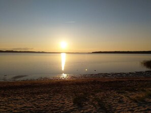 A calm lake at sunset with a clear sky.