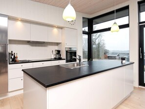 A modern kitchen with a large island, stainless steel appliances, and pendant lighting. - Simplistic Holiday Home in LÃ¸gstrup near Sea (Logstrup)