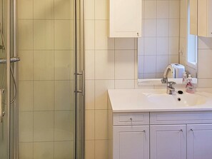 A bathroom with a shower, sink, mirror, and cabinets. - 10 Person Holiday Home in Urangsvåg (Bomlo)