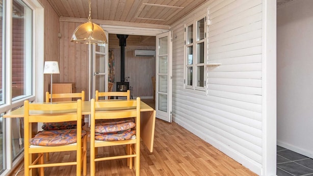 A wooden interior with a dining table and chairs, a hanging light fixture, and a view through an open door. - 6 Person Holiday Home in Grenaa-by Traum (Grenaa)