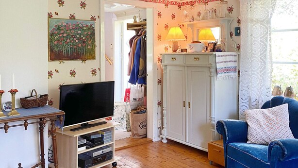 Un salon confortable avec un téléviseur, un canapé bleu et un meuble en bois.
