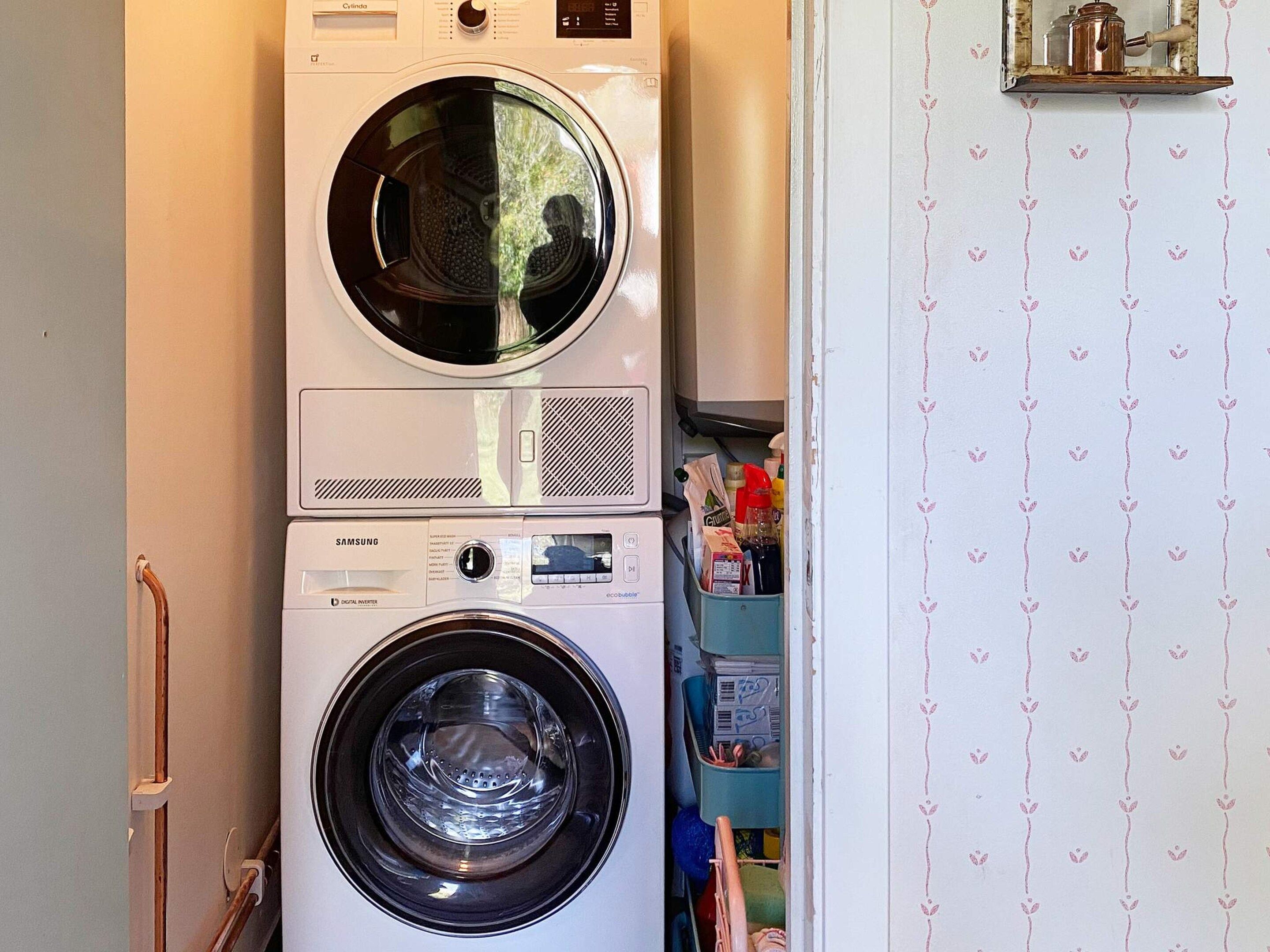 A stacked washer and dryer unit in a laundry room.