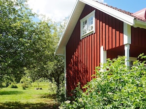 En rød bygning med et hvidt vindue og en hvid veranda.