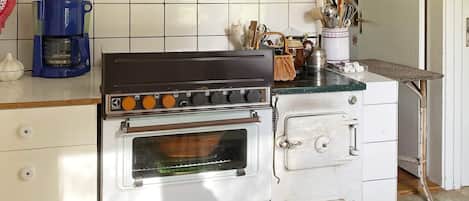 A kitchen with a stove, oven, and coffee maker.