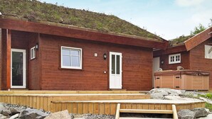 A wooden cabin with a front door, two windows, and a small porch area. - Holiday Home in Vevang (Hustadvika)