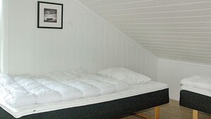 A room with a bed, a small table, and a picture on the wall.