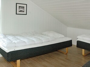 A room with a bed, a small table, and a picture on the wall.