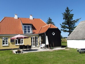 A house with a red-tiled roof, a black barn, and a white building with a grey roof. - 4 Star Holiday Home in Skagen (Skagen)