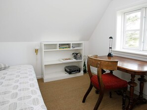 A room with a bed, a wooden desk, a chair, a bookshelf, and a window. - 4 Star Holiday Home in Skagen (Skagen)