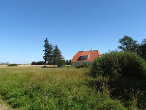 A house with a red roof, surrounded by grass and trees. - 4 Star Holiday Home in Skagen (Skagen)