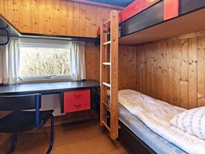 A bunk bed with a desk and chair, a window with curtains, and a ladder. - 8 Person Holiday Home in Vestervig (Vestervig)