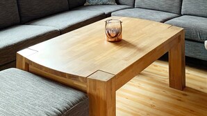 A modern living room with a wooden coffee table, grey sofa, and a patterned throw pillow. - 8 Person Holiday Home in Trysil (Trysil)