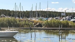 A marina with boats docked, surrounded by water and greenery. - Holiday Home in Lidköping (Lidköping)