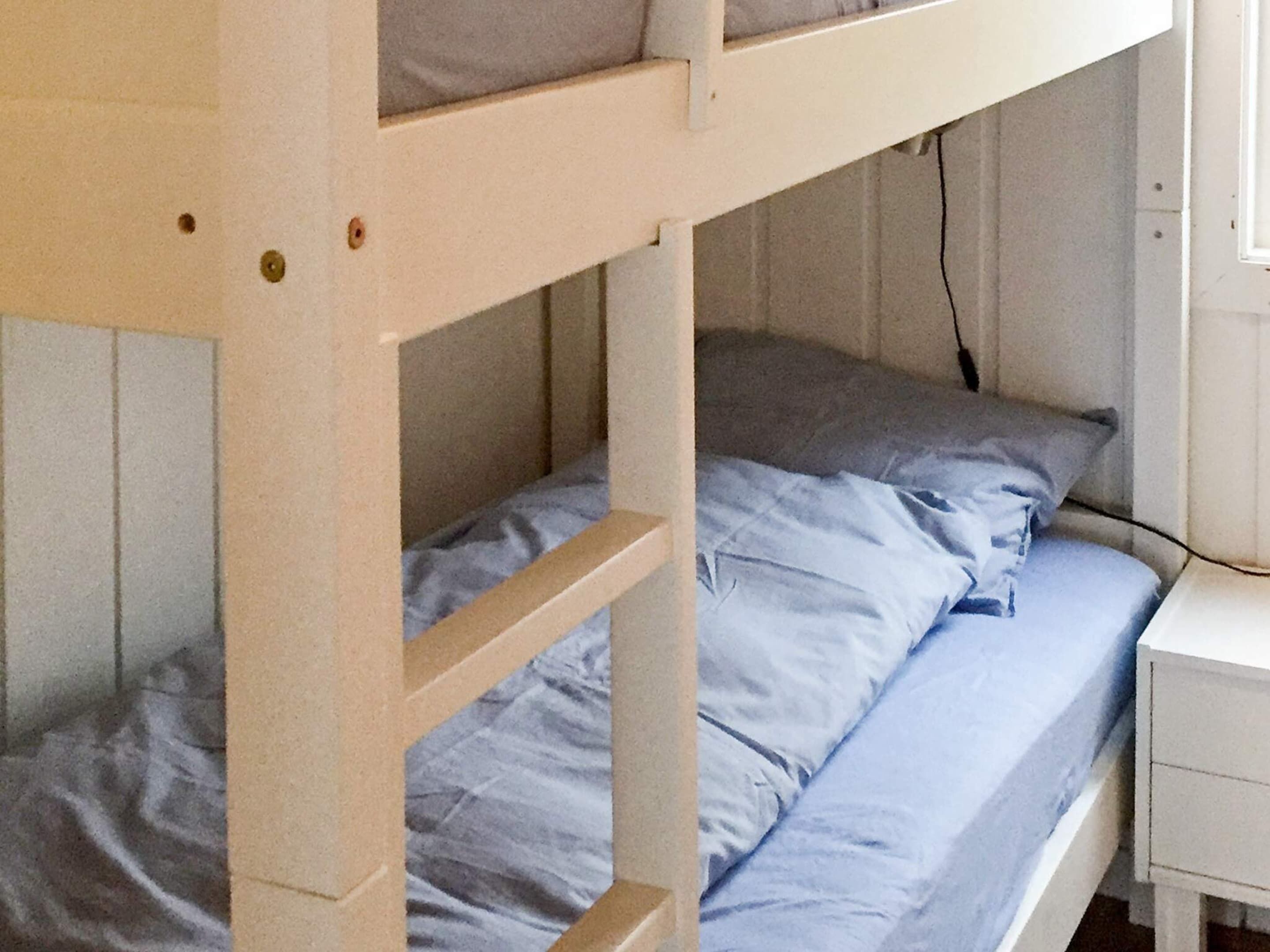 Ein Stockbett mit Schreibtisch und Fenster.