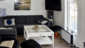 Ett vardagsrum med en soffa, ett soffbord och en tv.