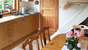 A kitchen with wooden cabinets, a sink, and a window with flowers. - 5 Person Holiday Home in Haverud-by Traum (Håverud)