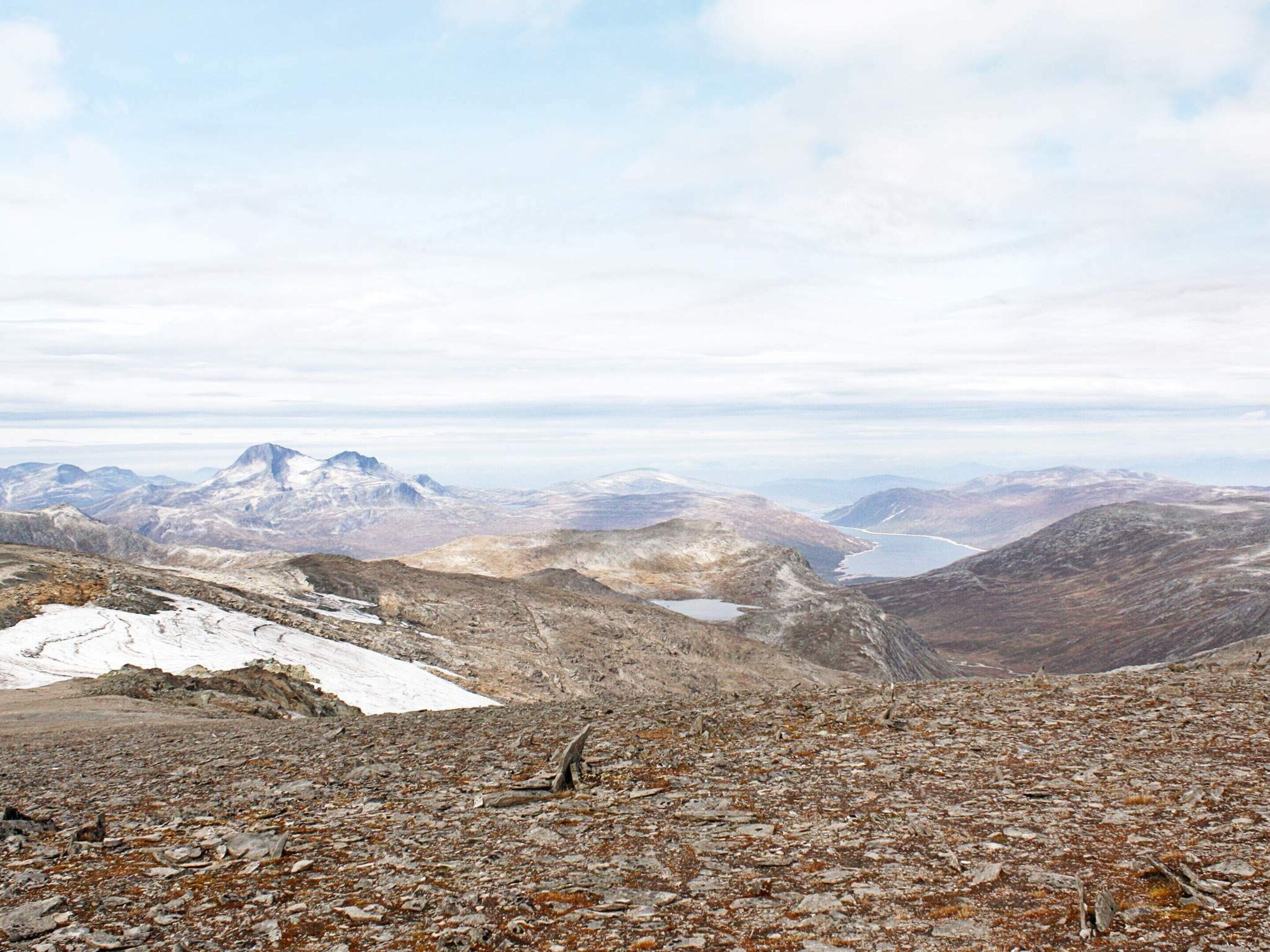 A mountainous landscape with rocky terrain and snow patches.