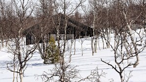 A snow-covered landscape with bare trees and a rustic building. - 4 Star Holiday Home in Rennebu (Rennebu)