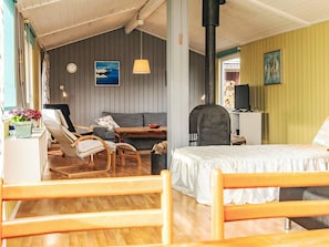 Une pièce confortable avec un lit, un canapé, une chaise en bois, une table et une cheminée.