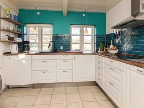 A kitchen with white cabinets, a coffee maker, and a window with a view. - 4 Star Holiday Home in Humble (Sydlangeland)