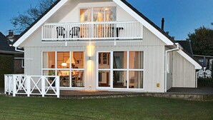 Un immeuble de deux étages doté d’un balcon, de grandes fenêtres et d’une entrée bien visible.