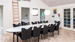 En moderne, åben planløsning med spiseplads, et soveværelse i loftet og et køkken.