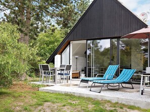 A modern house with a glass conservatory, outdoor seating, and a view of the surrounding trees. - Quaint Holiday Home in Sjaellands Odde near Sea (Sjællands Odde)