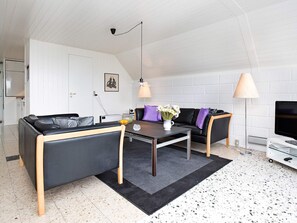 Un salon moderne avec un canapé, une table basse et deux lampes.